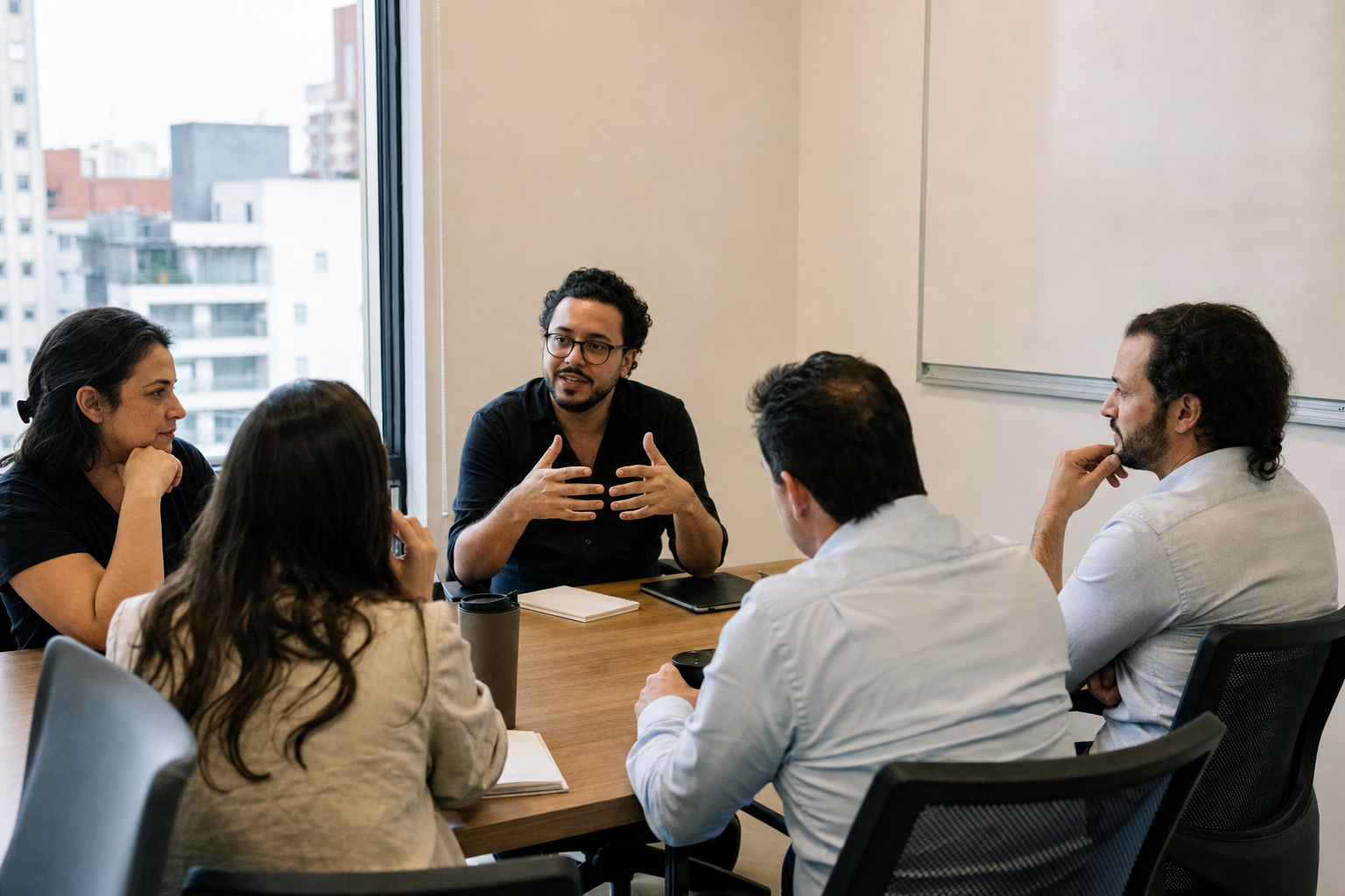 Tesserra team in an office meeting room — informal conversation, no screens.